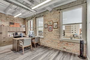 Office space featuring brick wall and light wood-style flooring