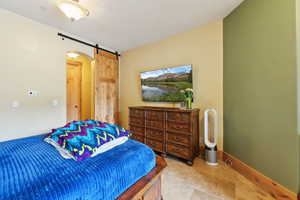 Bedroom with a barn door and baseboards