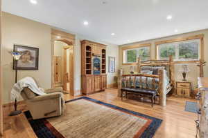 Bedroom featuring light wood finished floors, recessed lighting, baseboards, and arched walkways