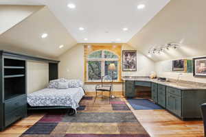 Bedroom featuring light wood finished floors, lofted ceiling, and recessed lighting