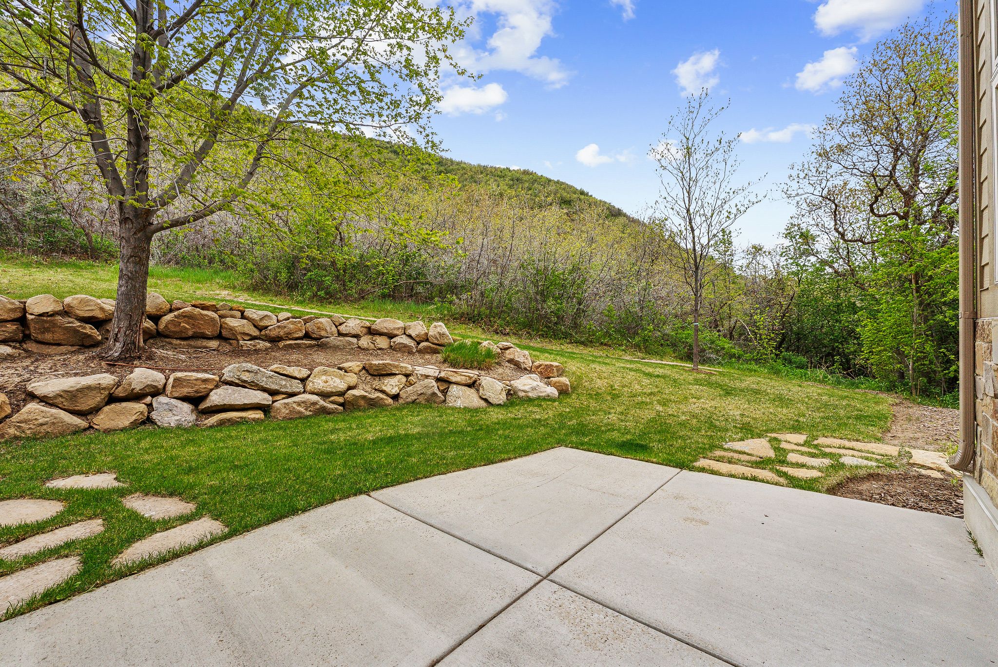 View of grassy yard featuring a patio area and a mountain view