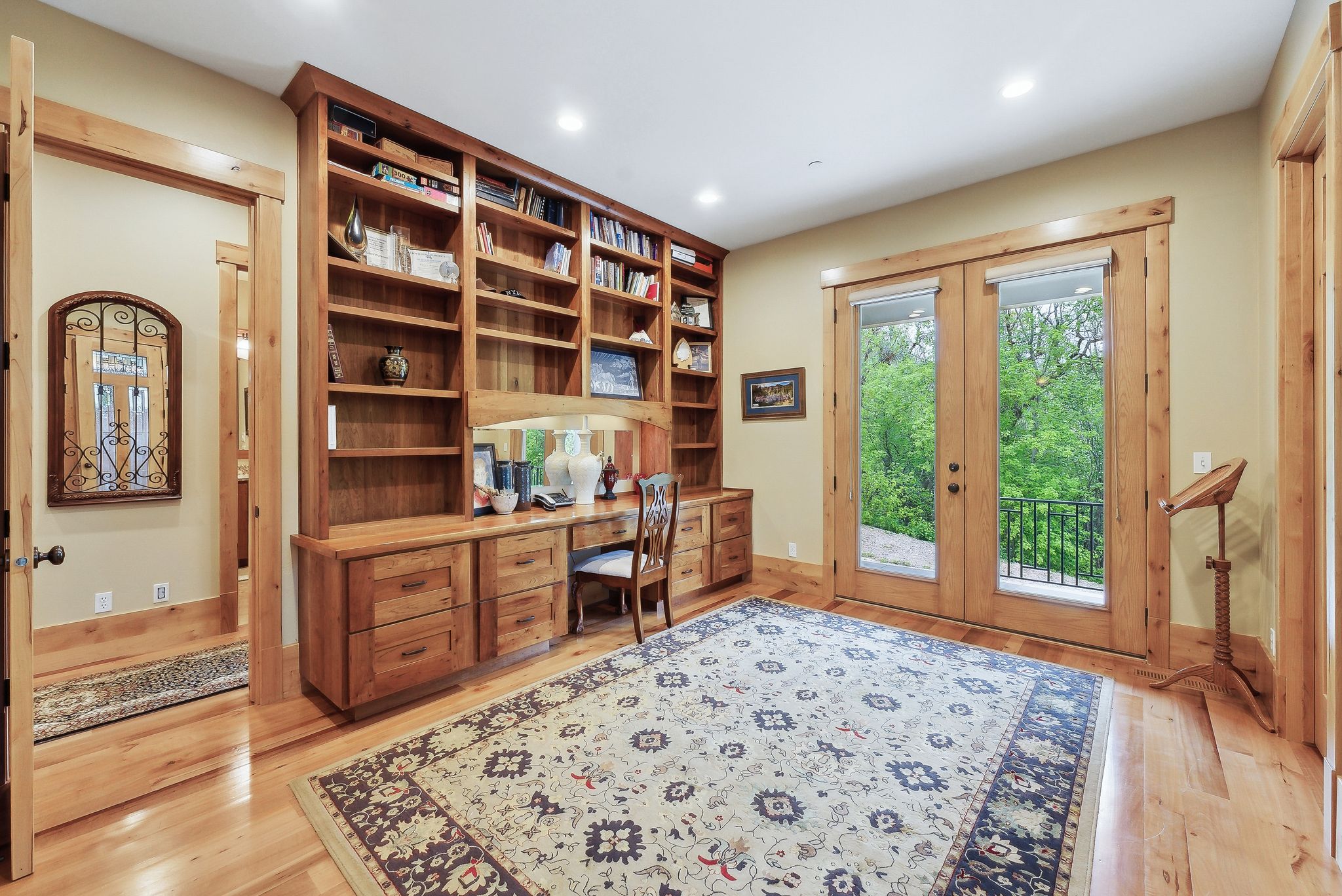 Home office with built in study area, french doors, light wood-style floors, recessed lighting, and baseboards