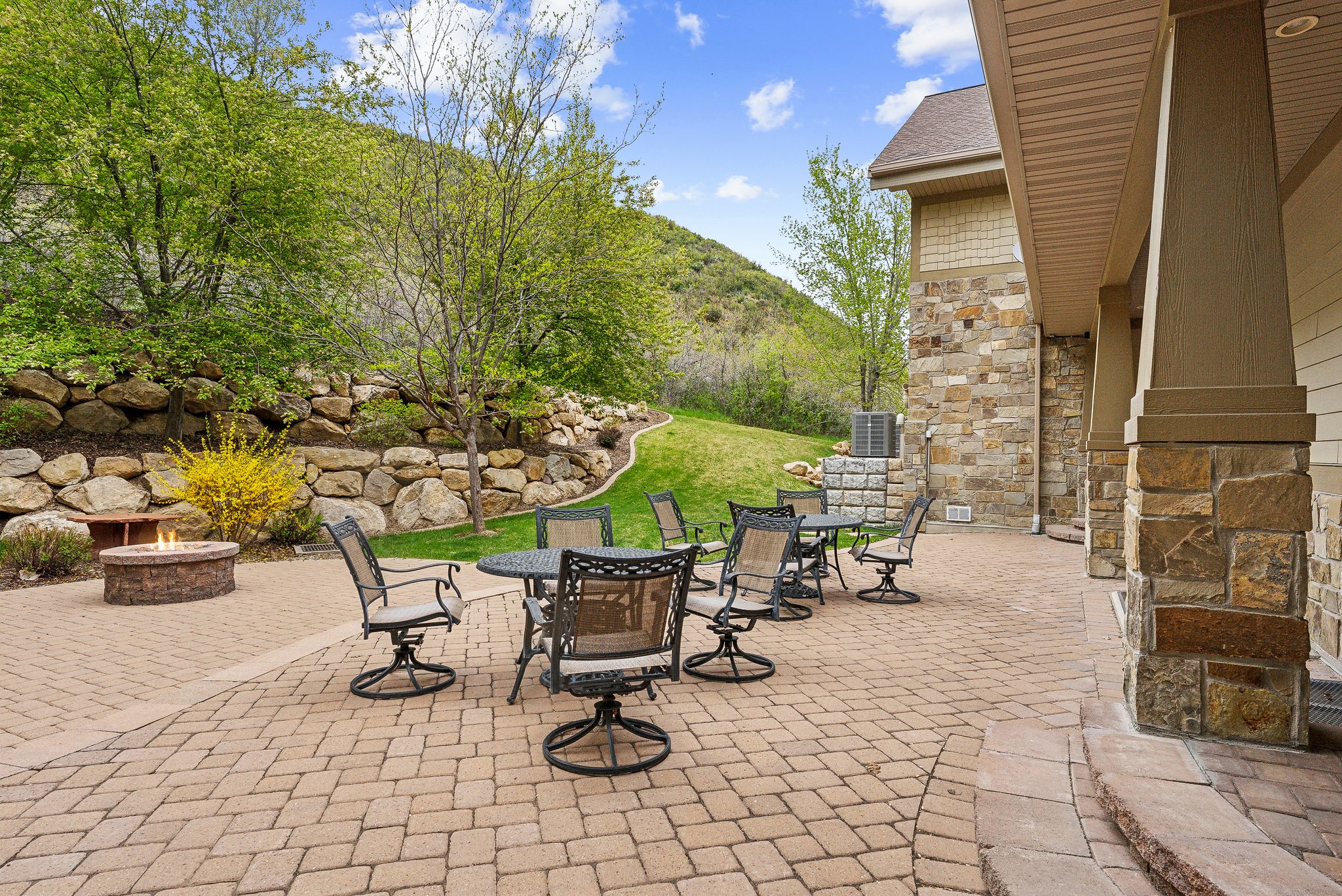 View of patio with an outdoor fire pit, outdoor dining area, a mountain view, and central air condition unit