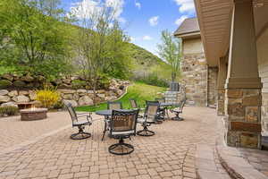 View of patio with an outdoor fire pit, outdoor dining area, a mountain view, and central air condition unit