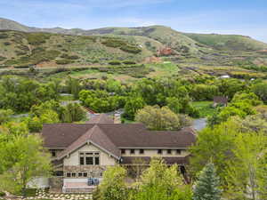 Aerial view of property and surrounding area with a mountainous background