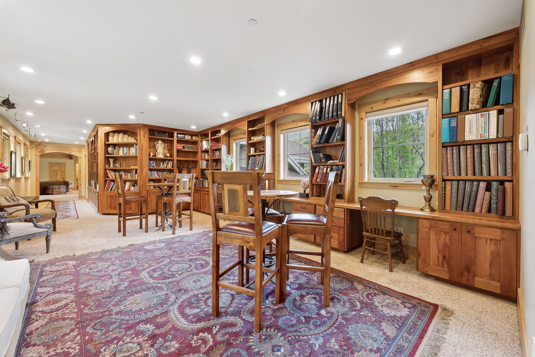 Carpeted dining space with arched walkways and recessed lighting