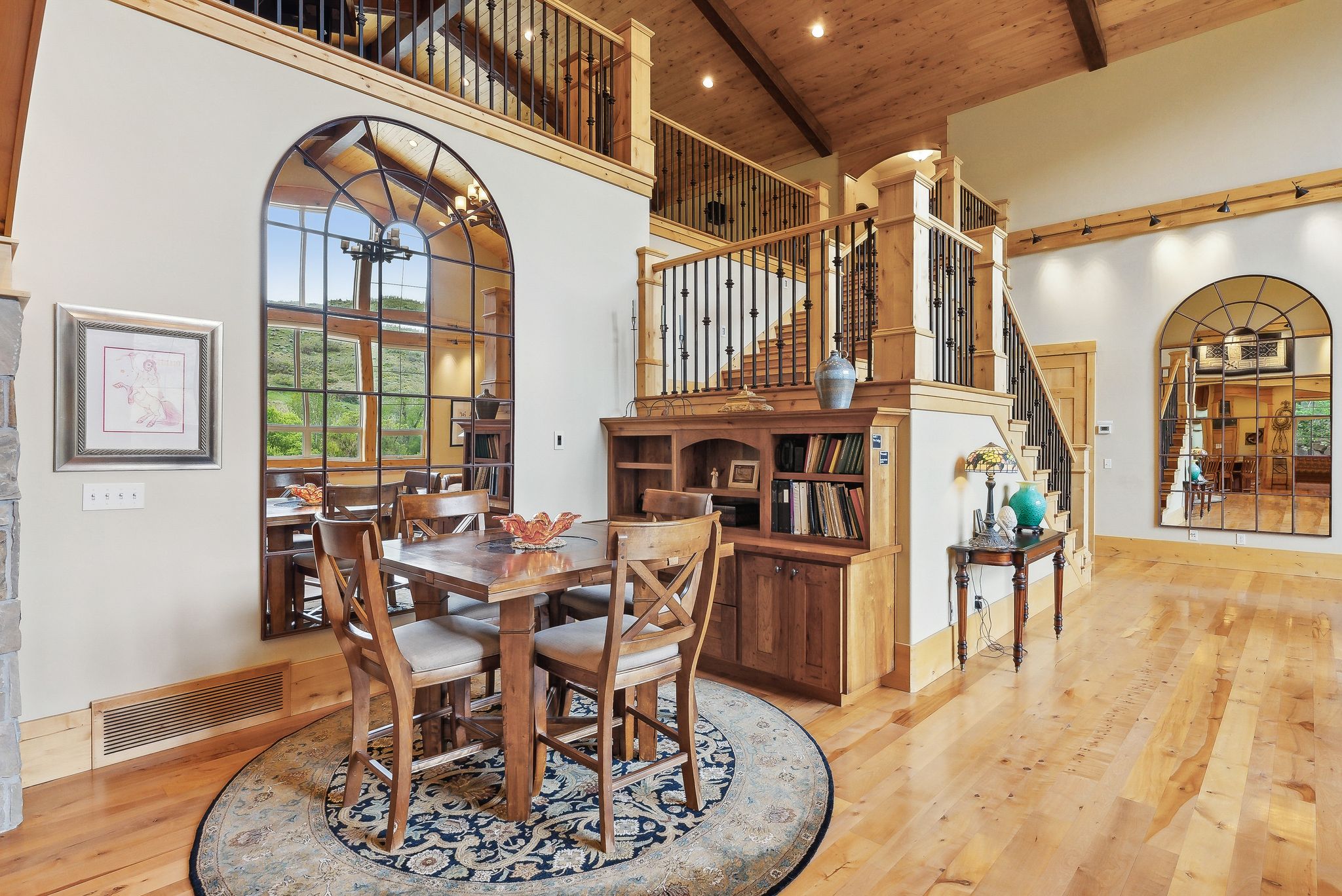 Dining area with high vaulted ceiling, wood ceiling, hardwood / wood-style flooring, beam ceiling, and stairway