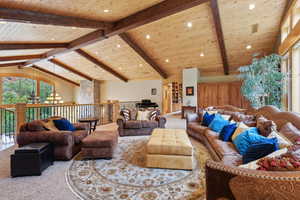 Carpeted living area with wooden ceiling, a chandelier, and recessed lighting