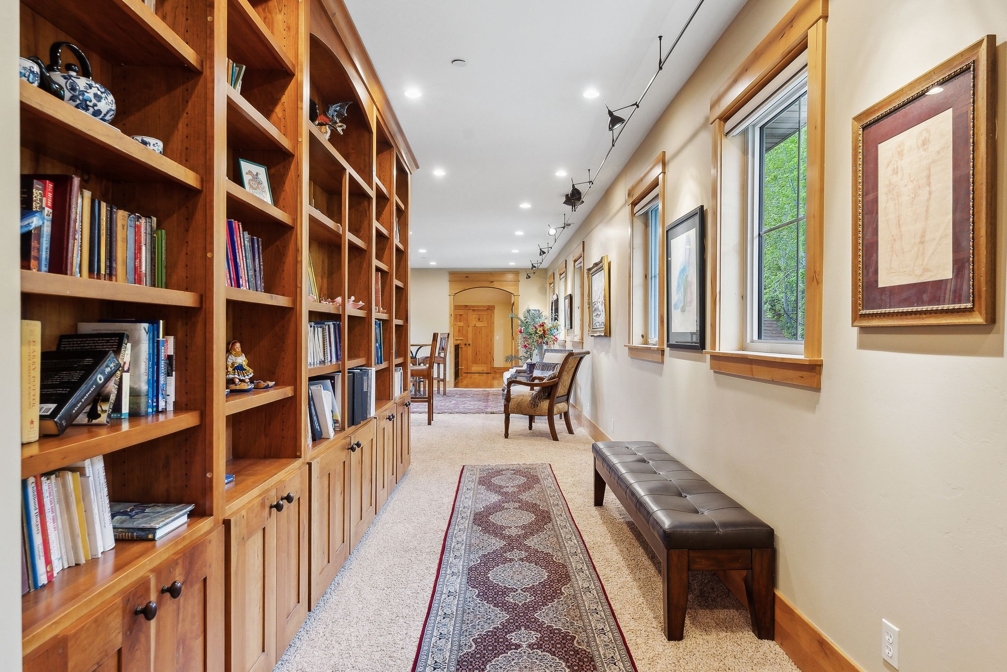 Hallway with arched walkways, light colored carpet, recessed lighting, and baseboards