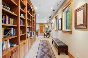 Hallway with arched walkways, light colored carpet, recessed lighting, and baseboards