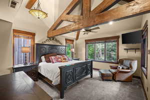 Carpeted bedroom featuring beamed ceiling and high vaulted ceiling