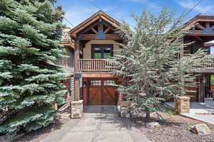 View of front of home with driveway, french doors, a balcony, and a garage