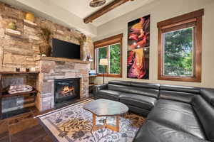 Living area with a fireplace, beamed ceiling, and healthy amount of natural light