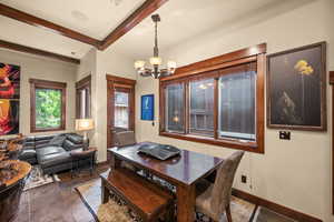 Dining area with beam ceiling, a chandelier, and stone finish floors