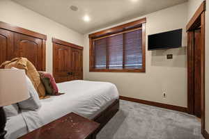 Carpeted bedroom with two closets and recessed lighting