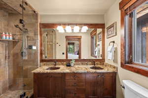 Full bath with double vanity, a shower stall, and ensuite bathroom