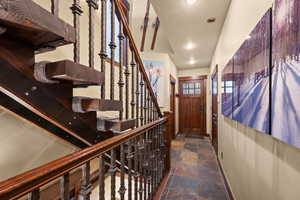 Staircase featuring stone tile flooring and recessed lighting