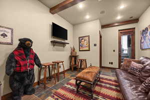 Living area with stone tile flooring, recessed lighting, and beamed ceiling