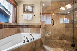 Full bath with a tub with jets and a shower stall