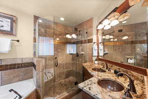 Bathroom with double vanity, a garden tub, and a stall shower