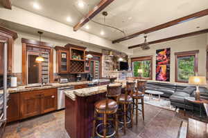 Indoor wet bar with dishwasher, beamed ceiling, tasteful backsplash, stone tile flooring, and hanging light fixtures