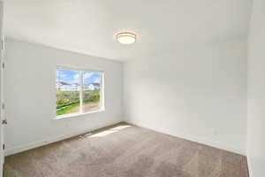 Carpeted empty room with baseboards