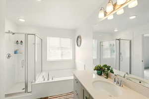 Bathroom featuring a shower stall, vanity, a garden tub, and recessed lighting