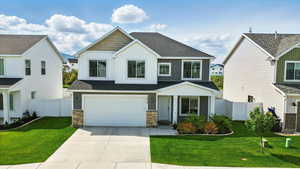 View of front facade featuring board and batten siding, concrete driveway, an attached garage, and a shingled roof
