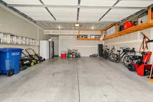 Garage with a garage door opener and freestanding refrigerator
