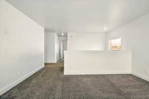 Unfurnished room featuring dark colored carpet, baseboards, and recessed lighting