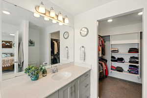 Bathroom featuring vanity, ensuite bathroom, toilet, a spacious closet, and recessed lighting