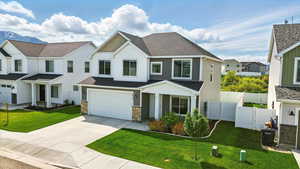 View of front of house featuring board and batten siding, concrete driveway, a garage, stone siding, and roof with shingles