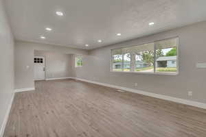 Spare room with recessed lighting, baseboards, and wood finished floors