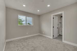 Empty room featuring light colored carpet, recessed lighting, and baseboards