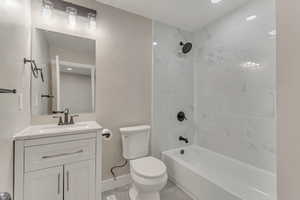 Full bath featuring toilet, vanity, baseboards, and shower / washtub combination