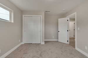 Unfurnished bedroom with carpet, baseboards, and a closet