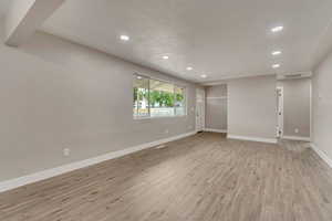 Spare room featuring recessed lighting, baseboards, and light wood finished floors