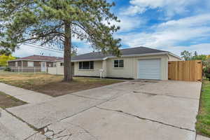 Ranch-style home featuring a garage and concrete driveway