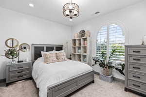 Bedroom featuring light colored carpet, baseboards, recessed lighting, and a chandelier