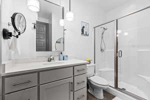 Full bathroom featuring a shower stall, vanity, and wood finished floors