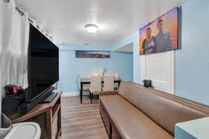 Living area with wood finished floors, a textured ceiling, and baseboards