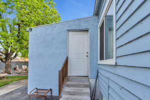 View of exterior entry featuring a patio area and fence