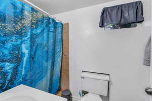 Full bath featuring toilet and a shower with shower curtain