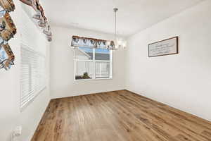 Dining area with wood finished floors, and chandelier