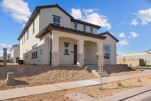 Mediterranean / spanish home with covered porch, stucco siding, stone siding, and a tile roof