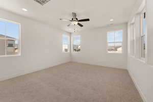 Unfurnished room with healthy amount of natural light, carpet floors, baseboards, recessed lighting, and a ceiling fan