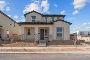 Mediterranean / spanish-style home with stucco siding, a porch, a tiled roof, and stone siding