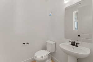 Bathroom featuring baseboards, a sink, and toilet