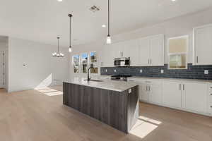 Kitchen featuring stainless steel appliances, a sink, backsplash, light wood-style floors, and recessed lighting