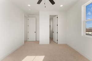 Unfurnished bedroom with light carpet, baseboards, recessed lighting, a ceiling fan, and a spacious closet